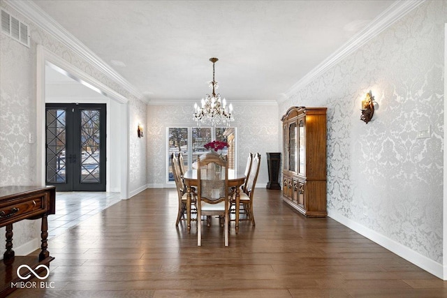 dining area with dark hardwood / wood-style floors, ornamental molding, a chandelier, and french doors