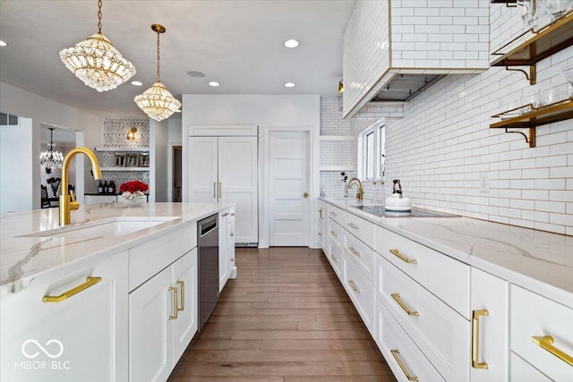 kitchen featuring decorative backsplash, sink, decorative light fixtures, an inviting chandelier, and white cabinets