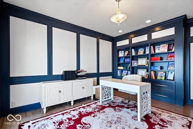 office area with hardwood / wood-style flooring, built in features, and crown molding