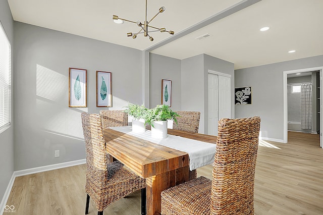 dining space featuring plenty of natural light, light hardwood / wood-style flooring, and a notable chandelier