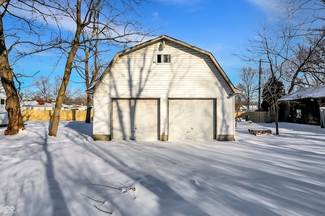 view of snow covered exterior with an outbuilding and a garage