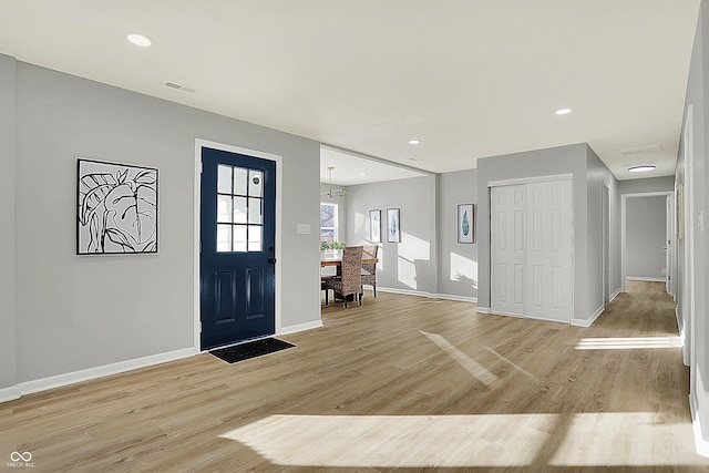 entryway featuring light hardwood / wood-style flooring and a notable chandelier