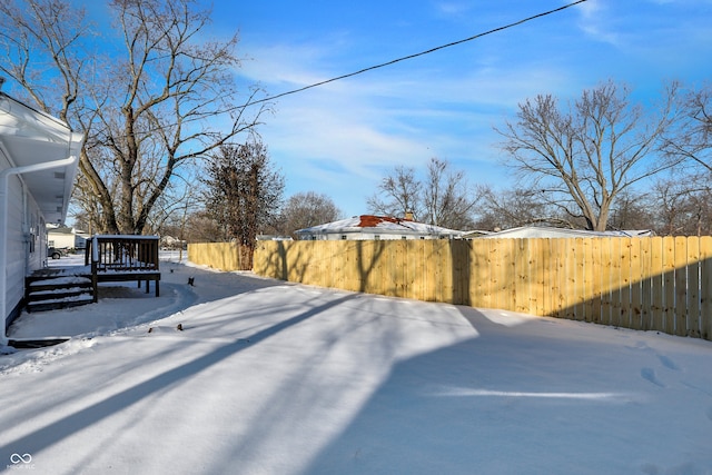 yard layered in snow featuring a deck