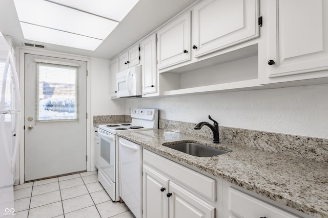 kitchen with sink, light stone counters, light tile patterned flooring, white appliances, and white cabinets