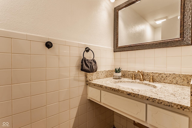 bathroom featuring vanity and tile walls