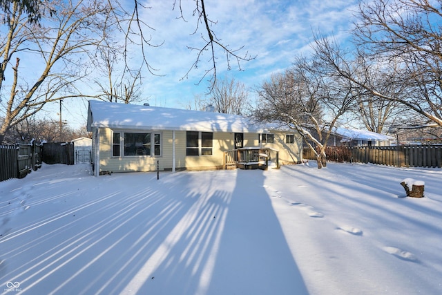 snow covered house with a wooden deck