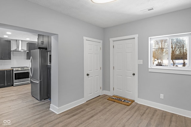 entrance foyer with a textured ceiling and light hardwood / wood-style flooring