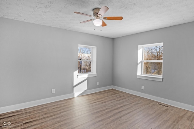 unfurnished room featuring ceiling fan, light hardwood / wood-style flooring, and a textured ceiling