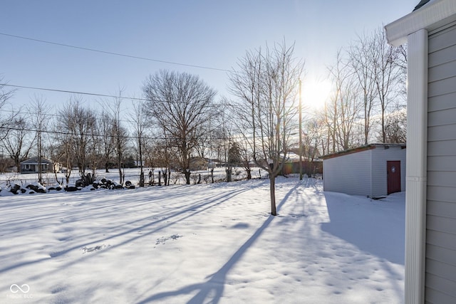 yard covered in snow featuring a storage unit