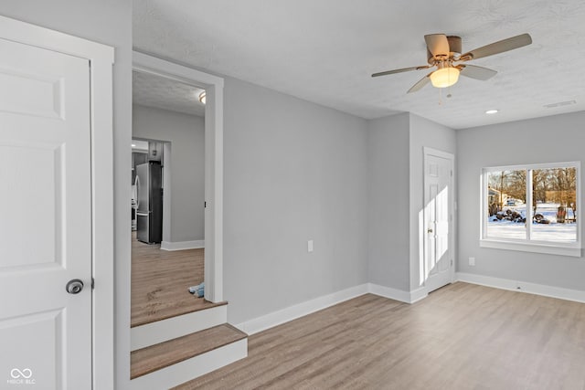 interior space with light hardwood / wood-style floors, a textured ceiling, and ceiling fan