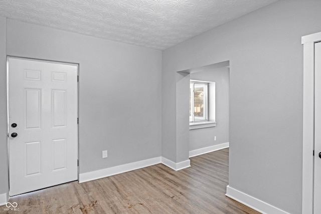 unfurnished room featuring hardwood / wood-style flooring and a textured ceiling