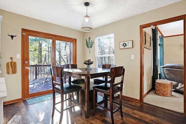 dining area featuring a textured ceiling, dark hardwood / wood-style flooring, and plenty of natural light