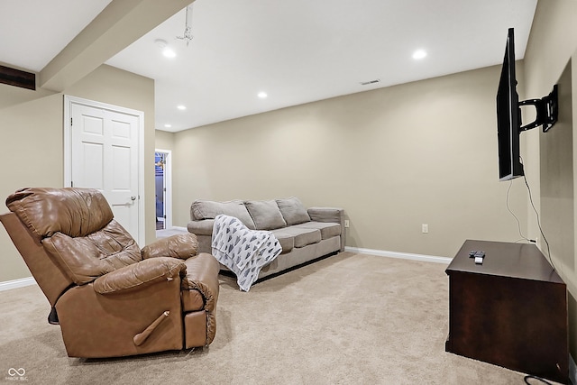 living room with beam ceiling and light colored carpet