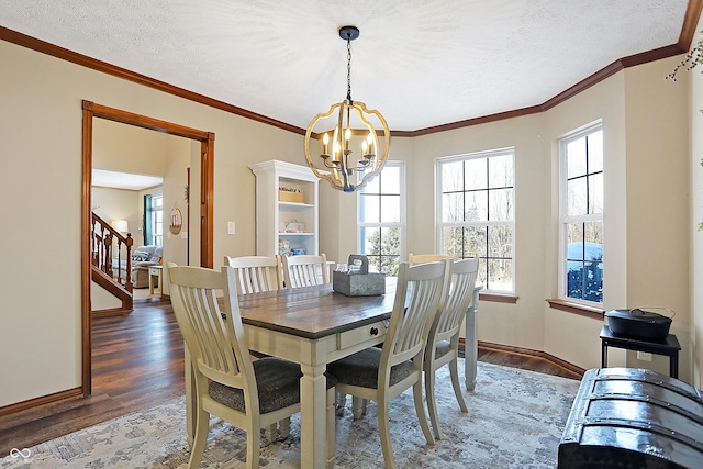 dining space featuring dark hardwood / wood-style floors, a healthy amount of sunlight, a textured ceiling, and an inviting chandelier