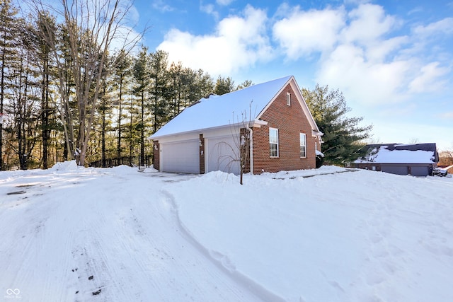 snow covered structure with a garage