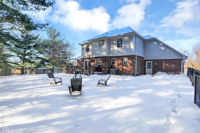 snow covered rear of property with central air condition unit