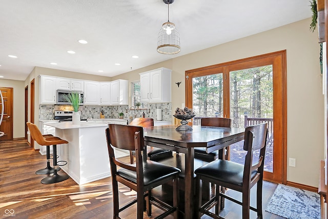 dining space with dark hardwood / wood-style flooring and sink