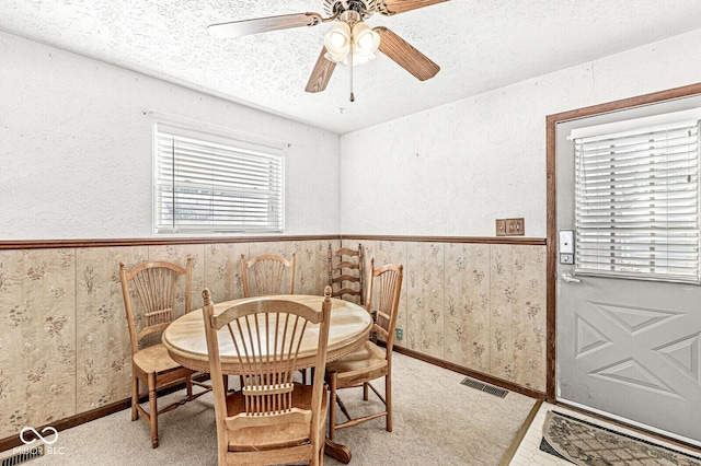 dining space with carpet flooring, ceiling fan, and a textured ceiling