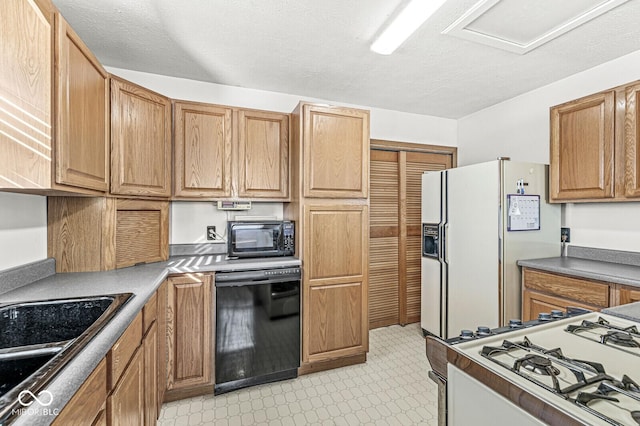 kitchen with sink, black appliances, and a textured ceiling