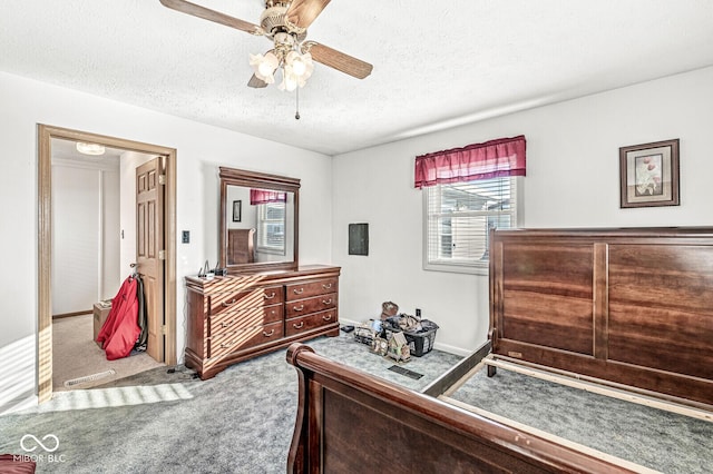 carpeted bedroom featuring ceiling fan and a textured ceiling