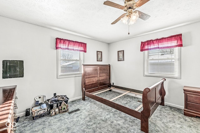 carpeted bedroom featuring ceiling fan and a textured ceiling