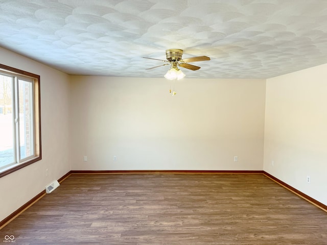 spare room featuring wood-type flooring, a textured ceiling, plenty of natural light, and ceiling fan