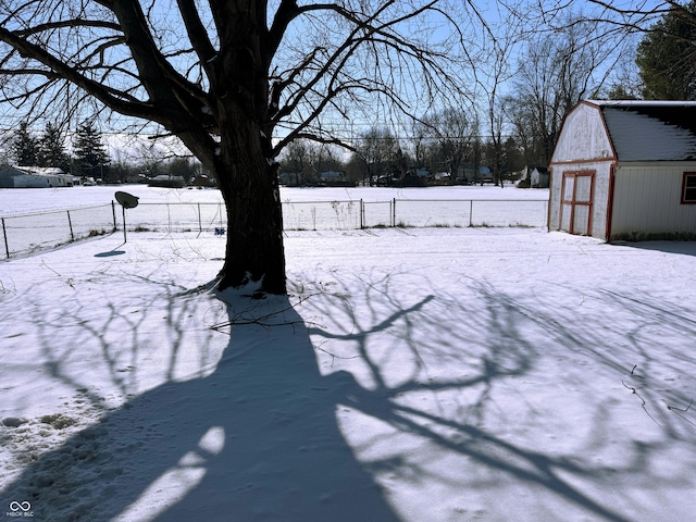 yard covered in snow featuring an outbuilding