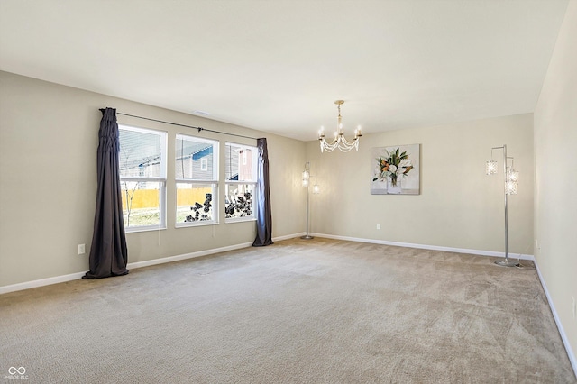 carpeted spare room featuring a chandelier