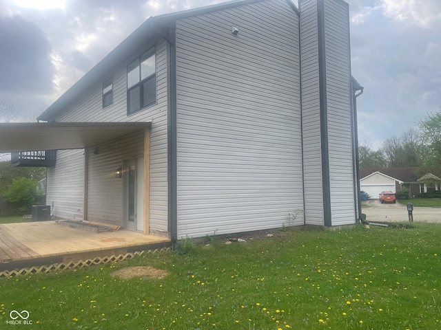 view of side of property featuring a wooden deck, central air condition unit, and a lawn