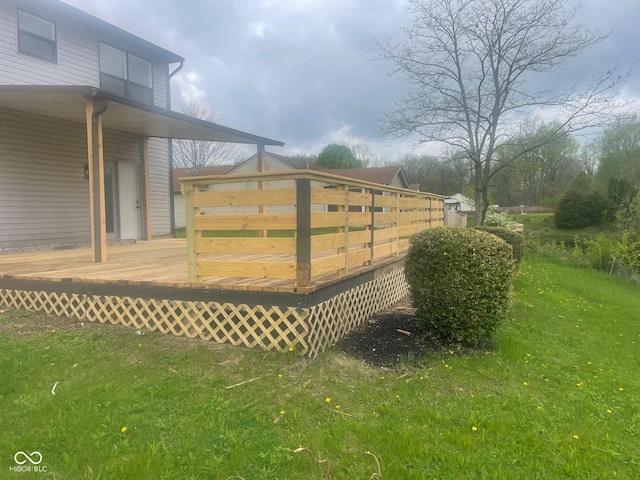 view of gate featuring a yard and a wooden deck