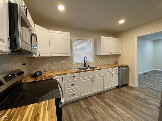 kitchen featuring butcher block counters, white cabinetry, sink, dark hardwood / wood-style flooring, and appliances with stainless steel finishes