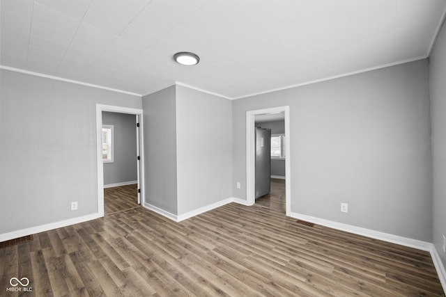 empty room featuring crown molding and dark hardwood / wood-style floors