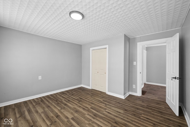 unfurnished bedroom with dark hardwood / wood-style flooring and a closet