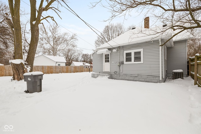 snow covered back of property with cooling unit