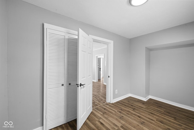 unfurnished bedroom featuring dark hardwood / wood-style flooring and a closet