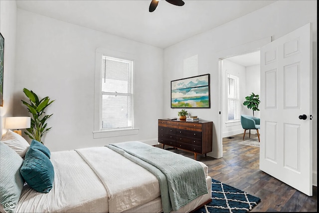 bedroom with multiple windows, dark hardwood / wood-style floors, and ceiling fan