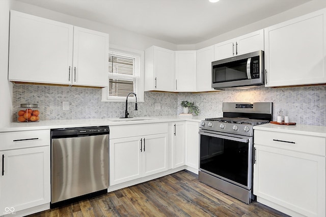 kitchen featuring stainless steel appliances, white cabinetry, sink, and dark wood-type flooring