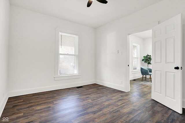 empty room featuring dark wood-type flooring and ceiling fan