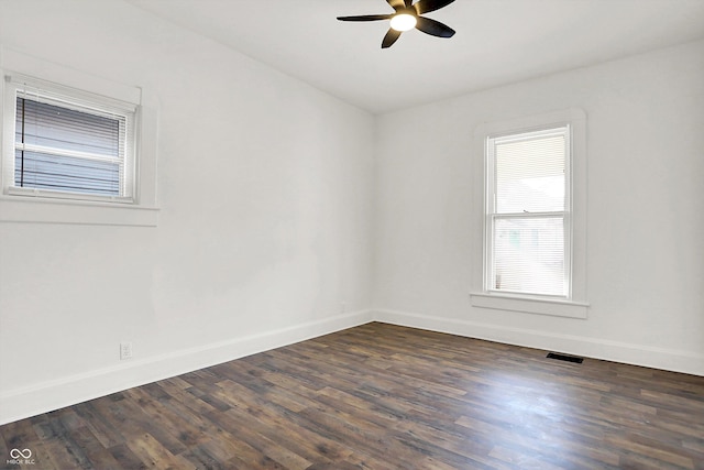 empty room with dark wood-type flooring and ceiling fan