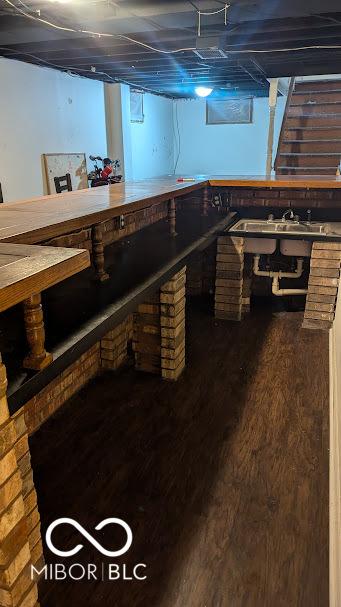 basement featuring sink, dark hardwood / wood-style floors, and a workshop area