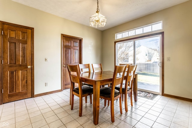 dining space with light tile patterned floors, a notable chandelier, baseboards, and a textured ceiling