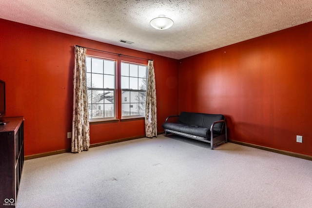 unfurnished room featuring visible vents, a textured ceiling, baseboards, and carpet floors