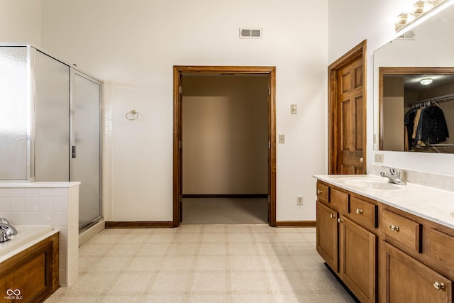 bathroom with a garden tub, baseboards, a stall shower, a sink, and tile patterned floors