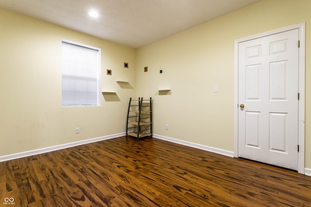 empty room with baseboards and dark wood-style floors