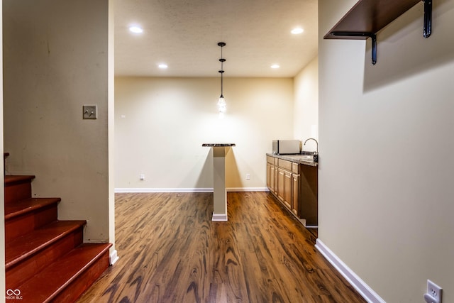 bar with recessed lighting, dark wood-type flooring, baseboards, and a sink