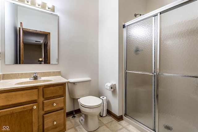 bathroom with vanity, toilet, baseboards, and a stall shower