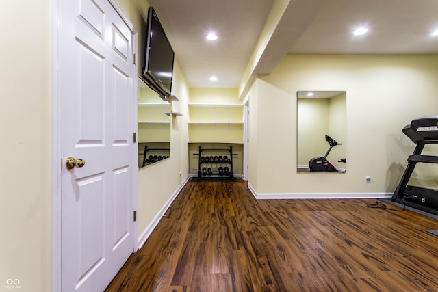 exercise room with dark wood finished floors, recessed lighting, and baseboards