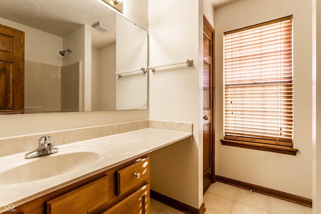 bathroom with tile patterned floors, visible vents, plenty of natural light, baseboards, and vanity