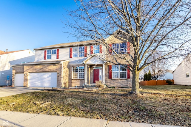 traditional-style house with brick siding, concrete driveway, and fence