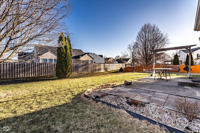 view of yard with a residential view, a fenced backyard, and a patio area